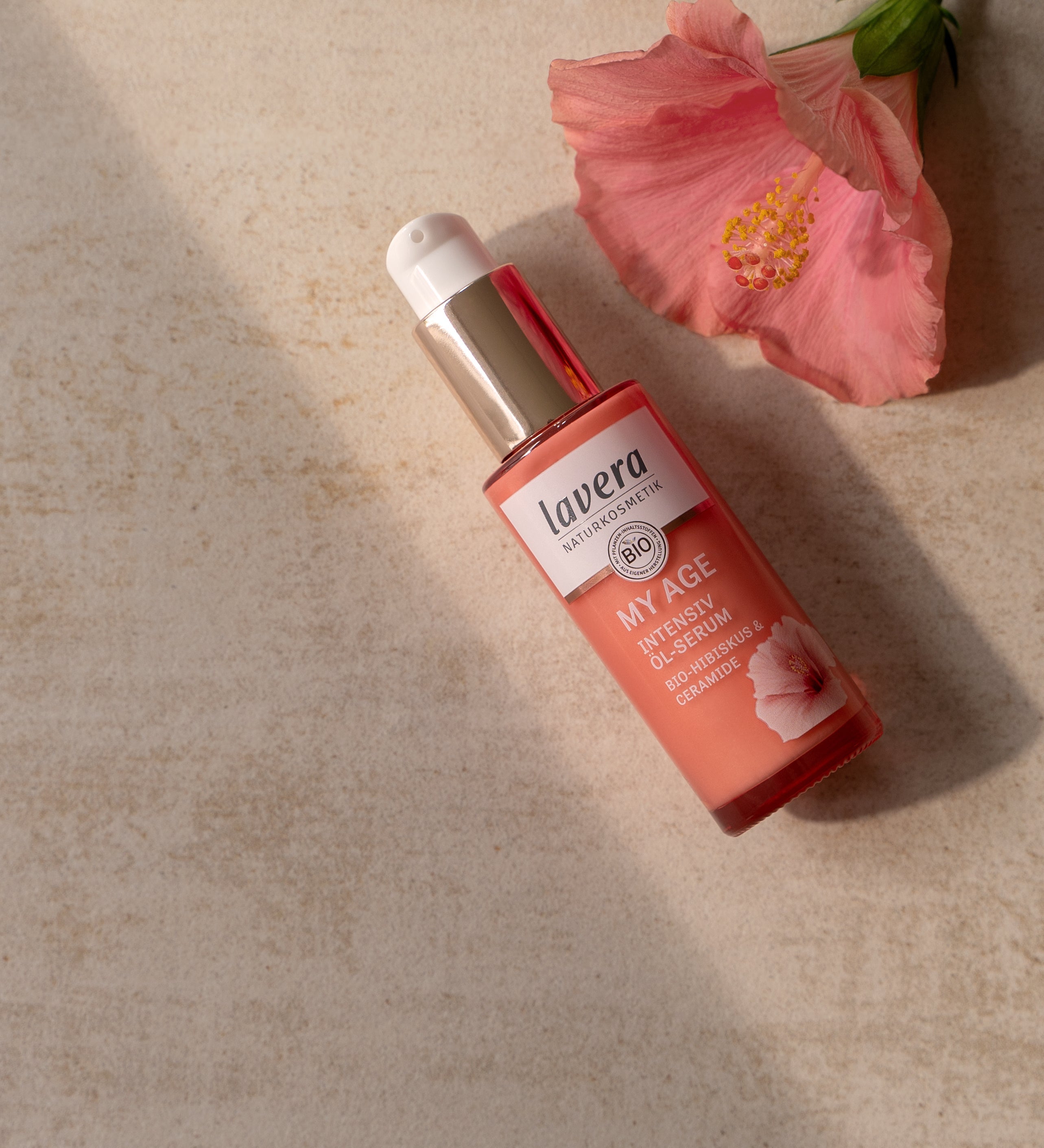 lavera My Age sérum huile intensif avec fleur d'hibiscus sur surface claire