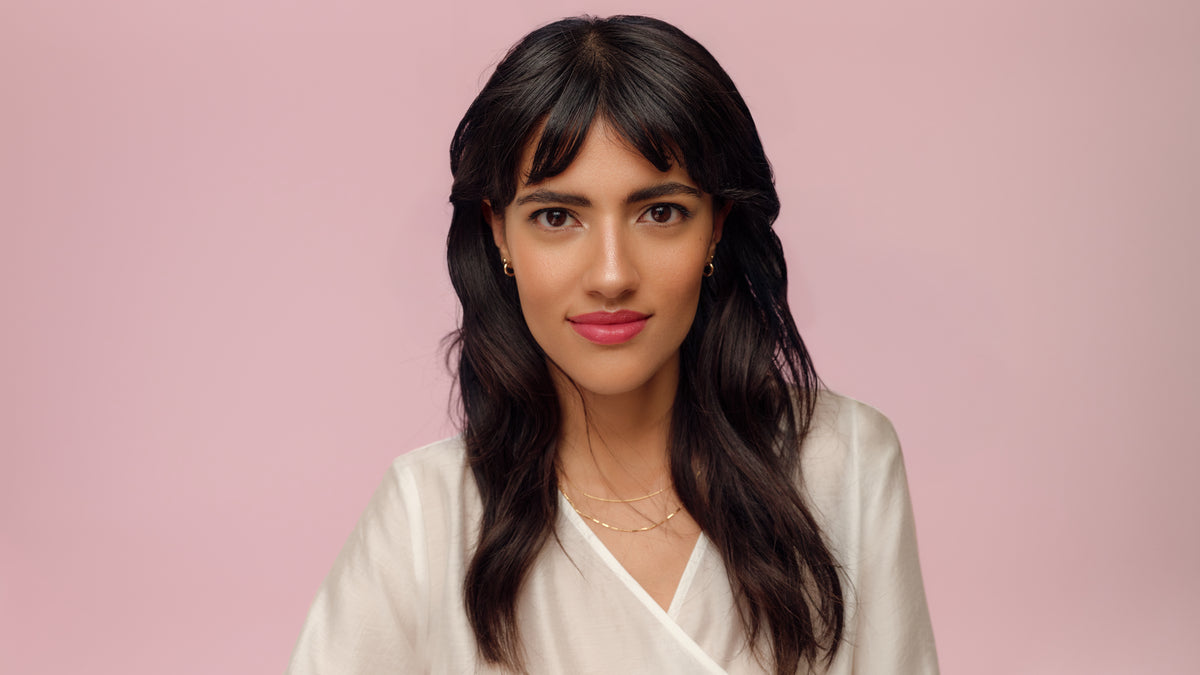 Jeune femme aux cheveux brun foncé, yeux bruns et un look maquillage élégant