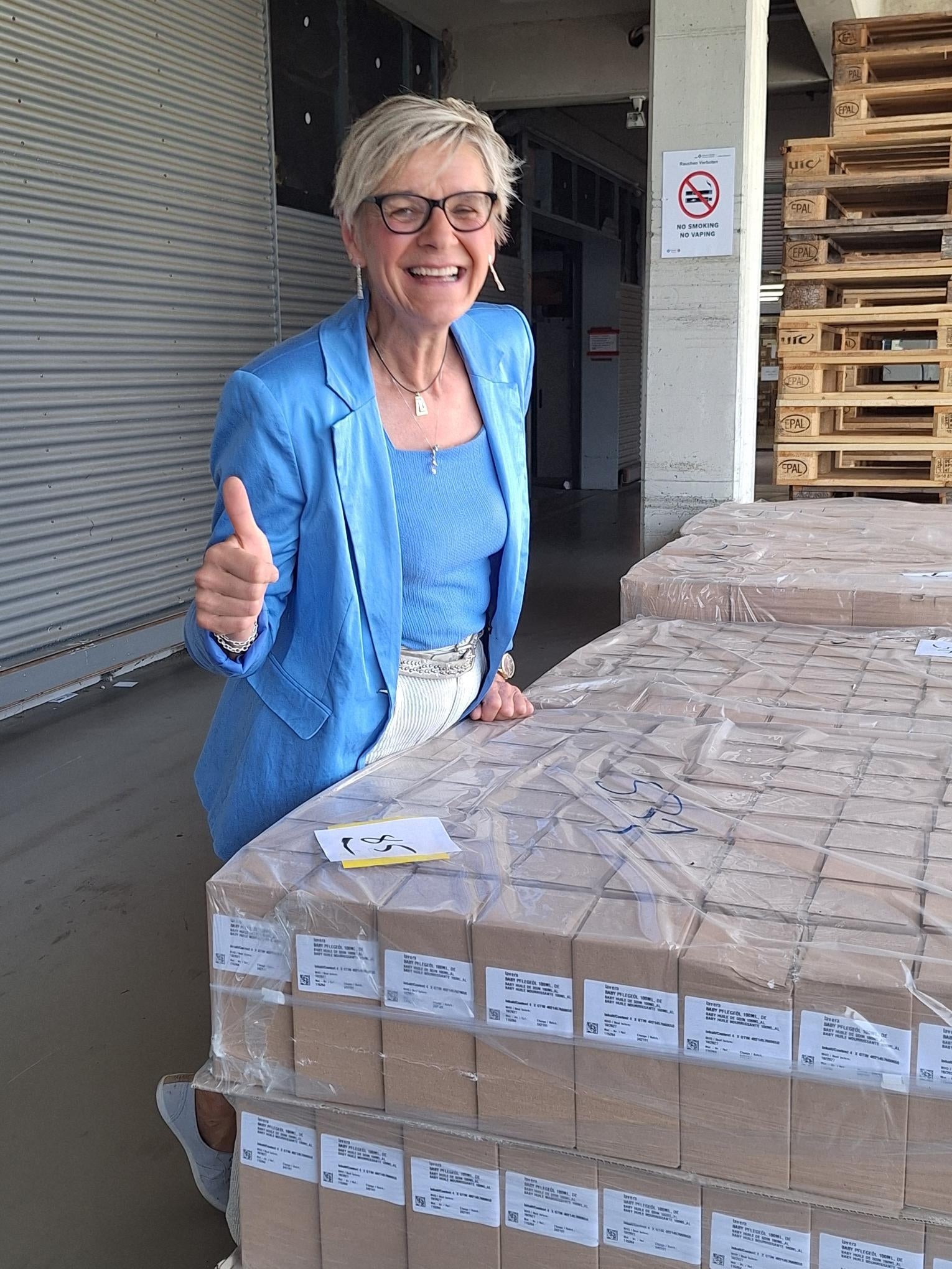 Sabine Kästner neben Paletten mit Produkten