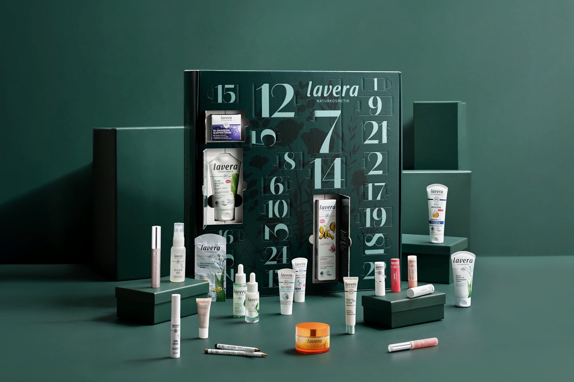 Calendrier de l'Avent lavera ouvert avec mini-produits de soin et maquillage sur fond vert