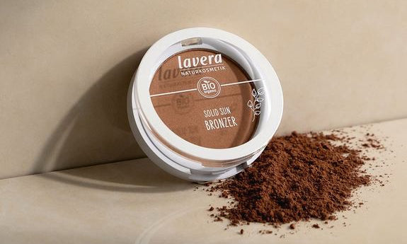 Geöffneter lavera Solid Sun Bronzer mit Puder auf beiger Fläche