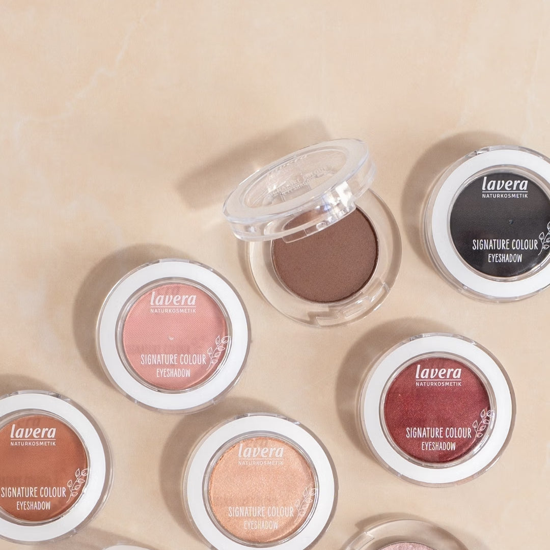 Les fards à paupières lavera Signature Colour, dans différentes teintes, sont posés sur une surface claire en marbre.