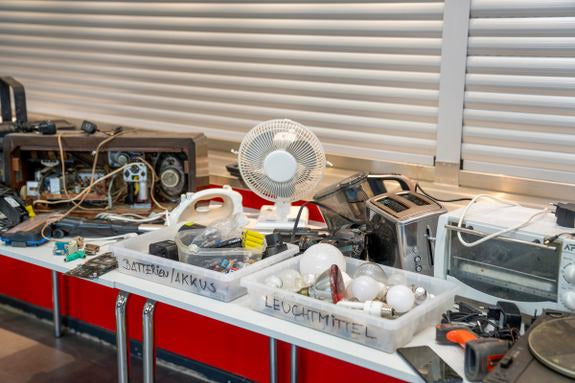 Déchets électroniques sur table : anciens appareils, câbles et boîtes pour piles et ampoules