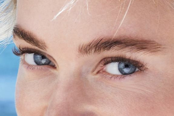 Yeux bleus avec fard à paupières discret, gros plan du visage