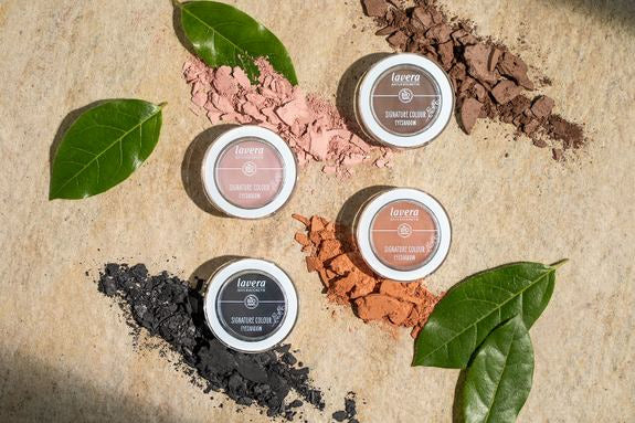 Quatre fards à paupières lavera décorés avec pigments de couleur et feuilles vertes