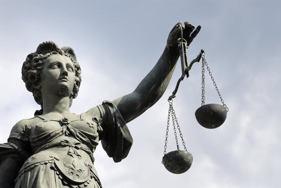 Statue de Justitia avec balance devant le ciel