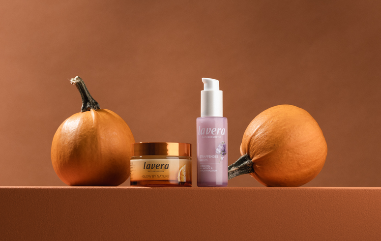 Glow by Nature Creme und Straffendes Serum zwischen 2 Kürbissen