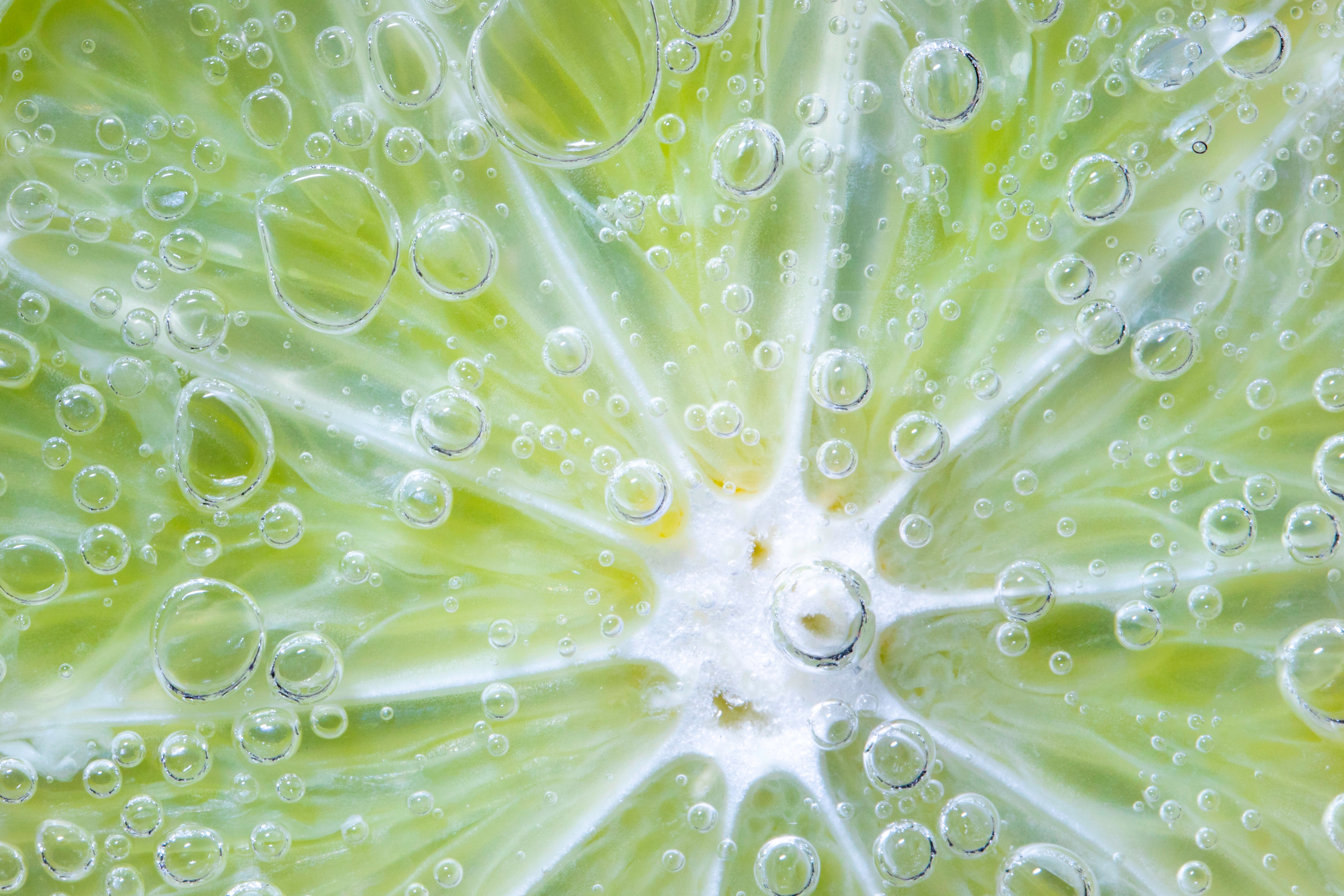 Nahaufnahme einer Limette mit Wasser und Luftblasen