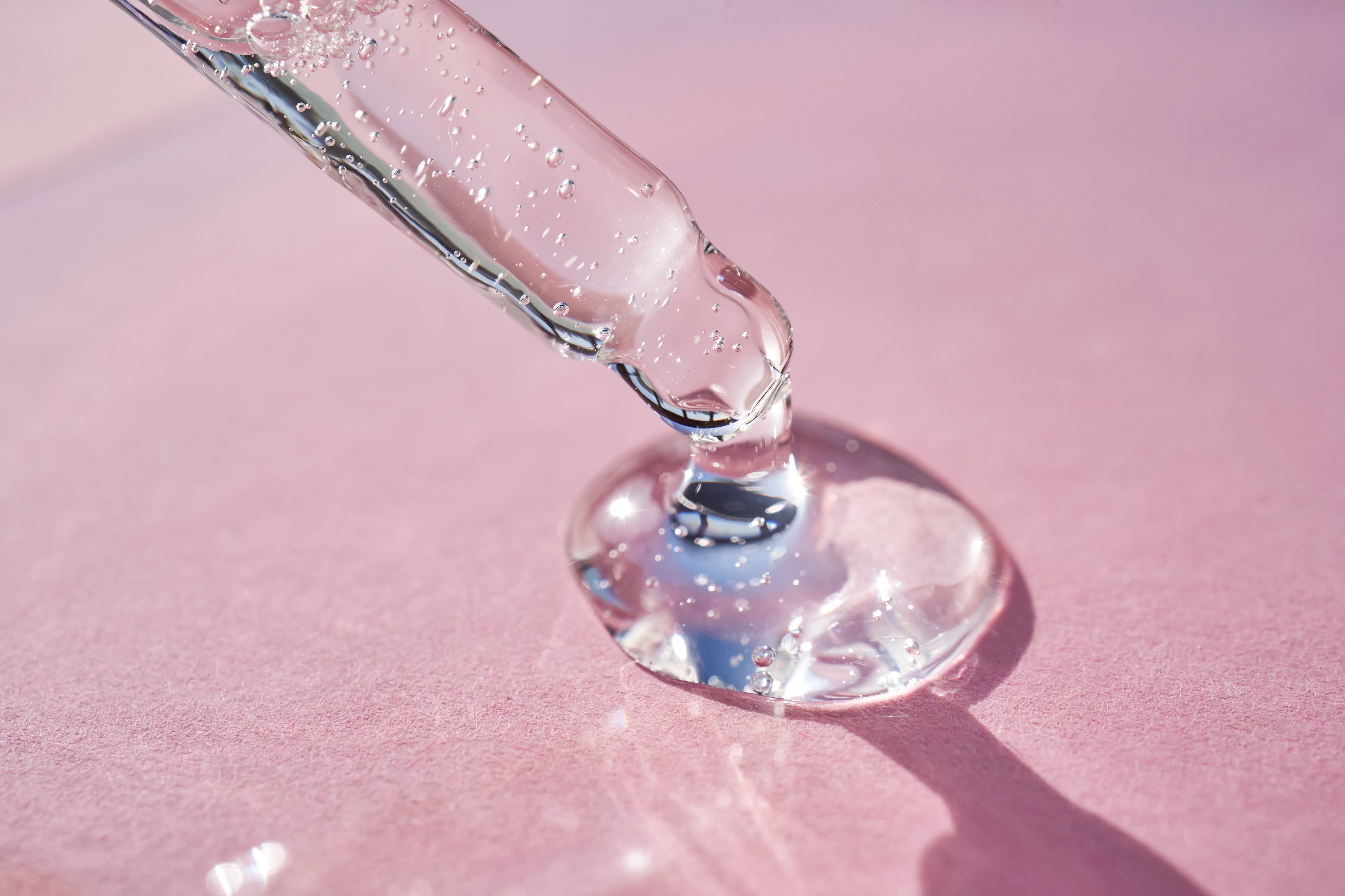 Pipette avec sérum sur fond rose