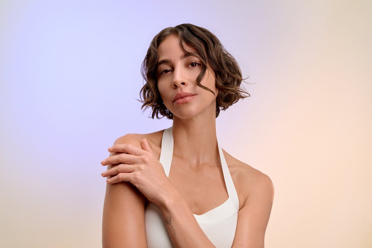 Portrait d’une femme aux cheveux bruns, bouclés et mi-longs.