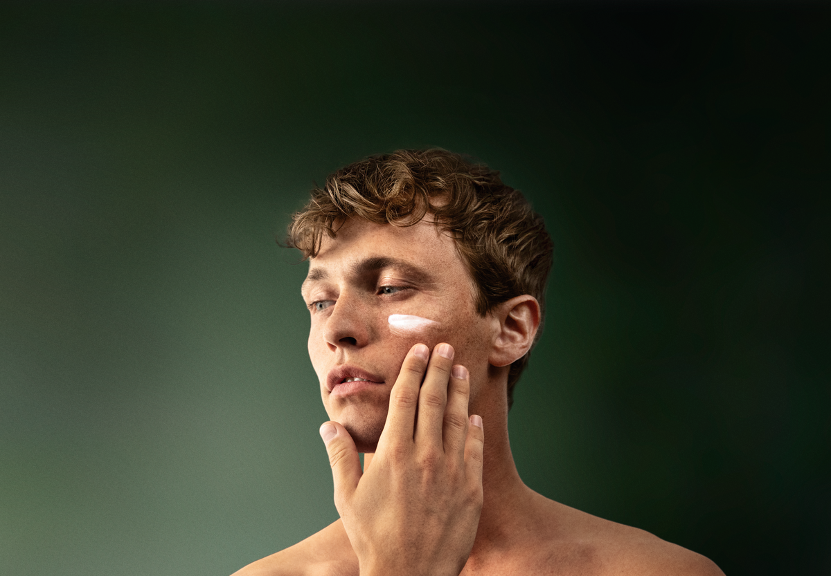 Un homme applique la crème hydratante lavera Men sensitive sur son visage
