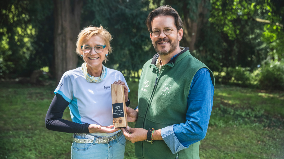 Mann von LifeTerra und Sabine Kästner nebeneinander und halten hölzerne Auszeichnung