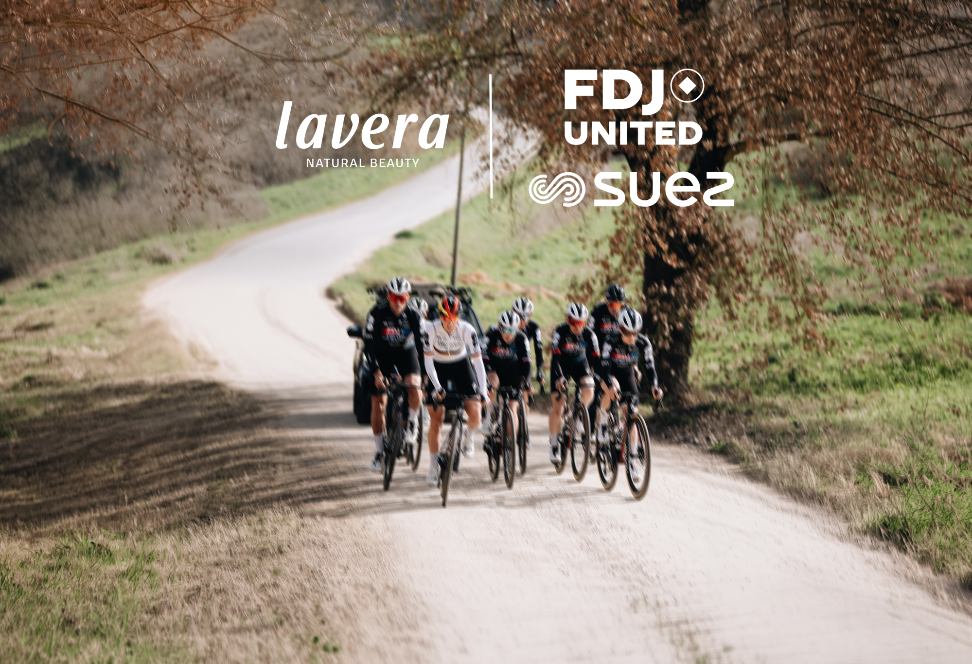 Gruppe von Profi-Radsportlerinnen fährt auf einer Kiesstraße