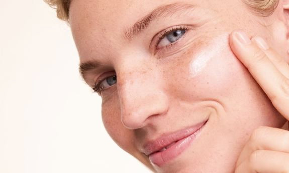 Creme wird auf die Wange aufgetragen