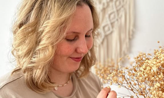 Femme regardant des fleurs séchées dans sa main