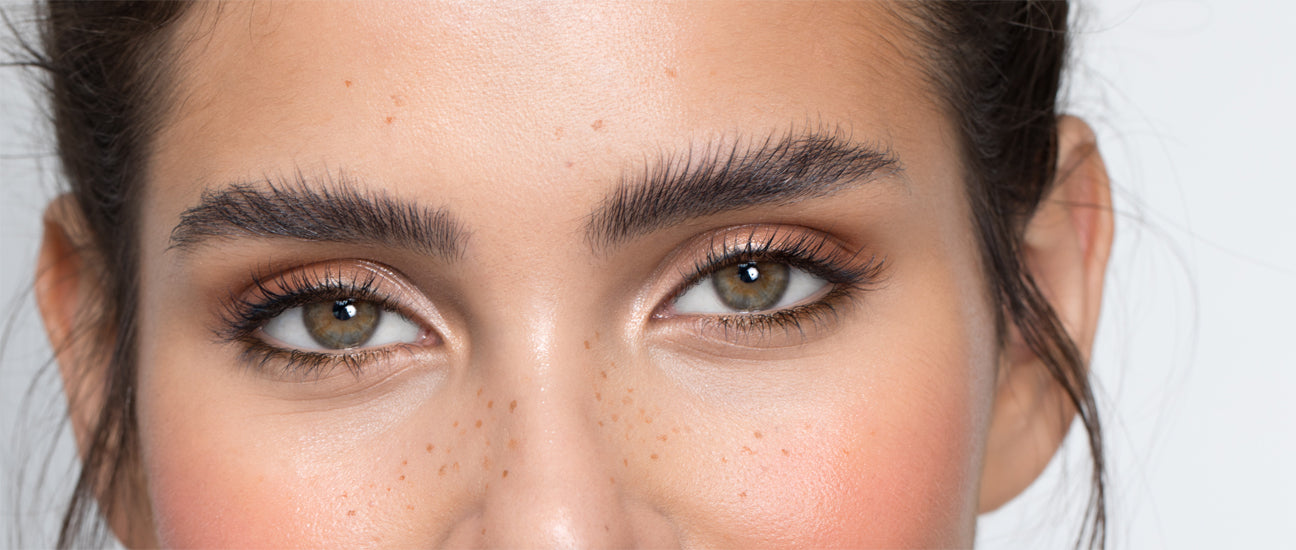 Gros plan d'une jeune femme aux cheveux bruns avec yeux marron clair et sourcils bruns stylisés