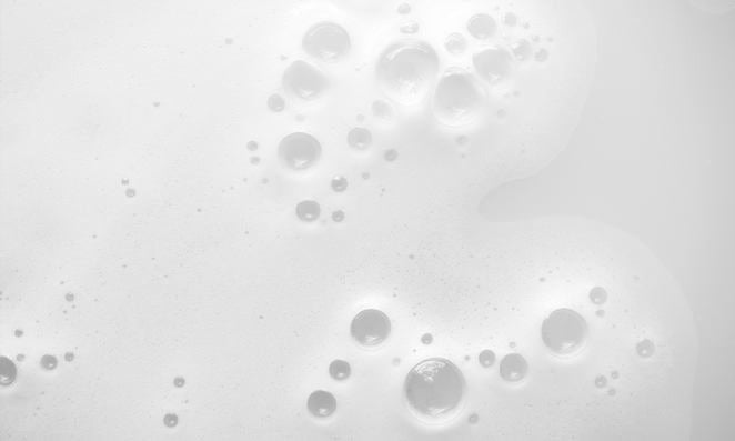 Macro : bulles de mousse blanches et gouttes sur fond clair