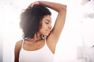 Femme levant le bras et regardant la caméra avec assurance