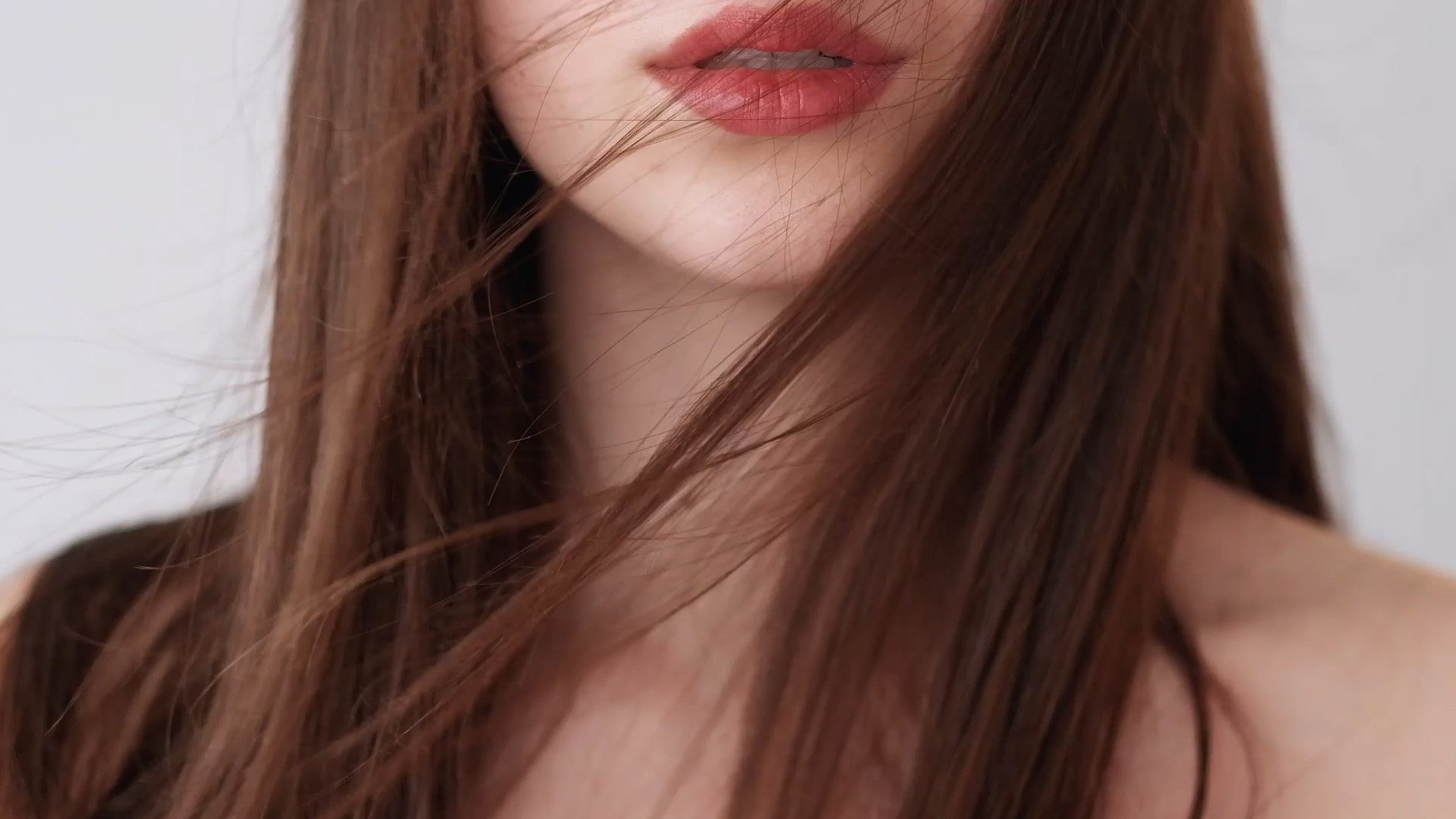 Nahaufnahme einer Frau mit langen, glatten Haaren und gepflegten Lippen