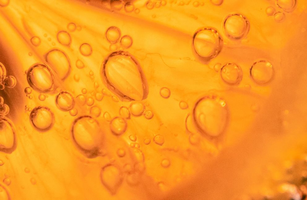 Macro : texture d'huile orangée avec bulles d'air, fond de sérum