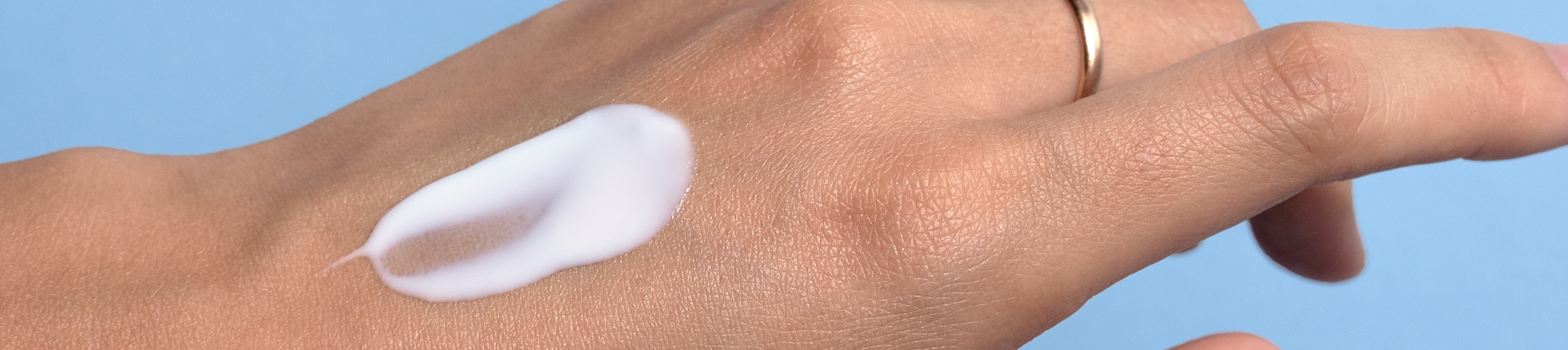 Creme lavera Naturkosmetik Une touche de crème repose sur le dos de la main d’une femme